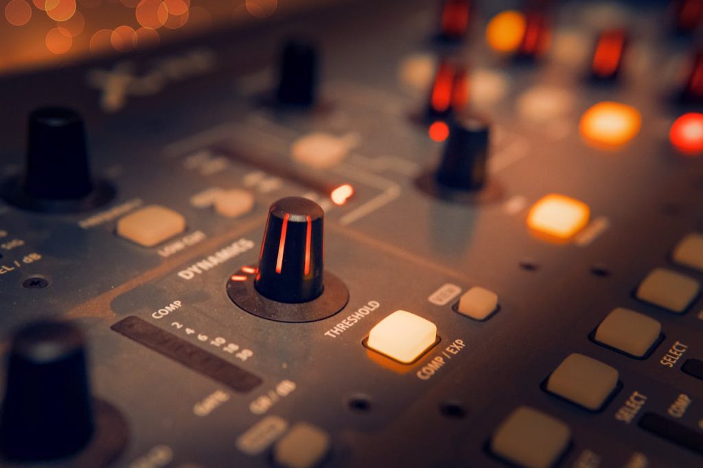 black-and-gray-audio-mixer-3784221 A detailed view of an audio mixer with glowing knobs, perfect for music production themes.